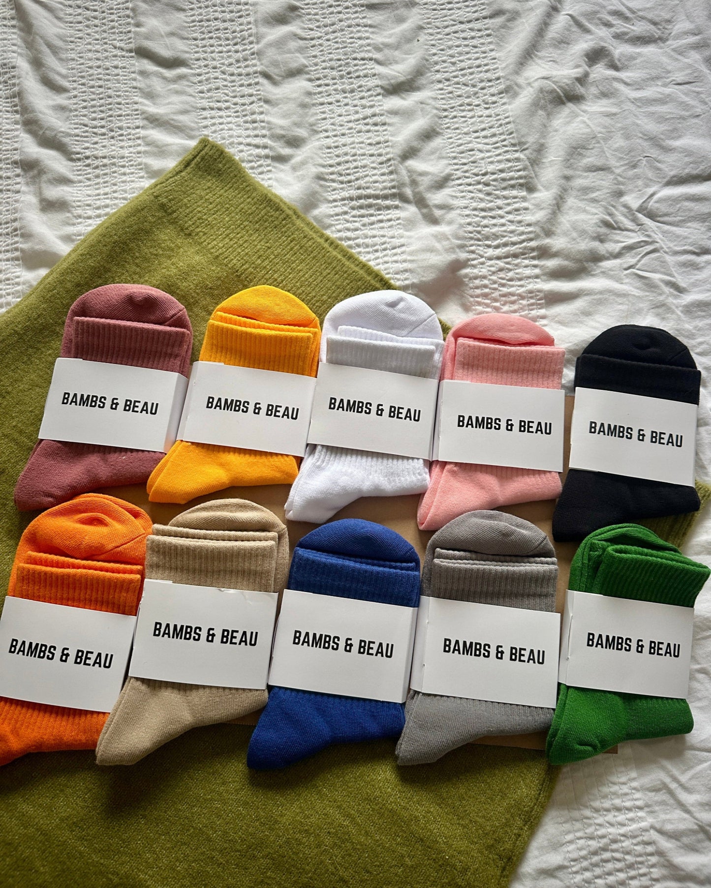 Assorted pairs of socks with 'BAMBS & BEAU' labels on a textured surface.